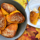Bowl of Sweet Potato Parker House Rolls and one sliced open on a plate with butter